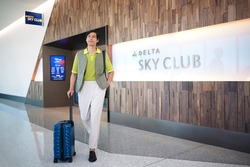 Uomo che esce dal Delta Sky Club con i bagagli